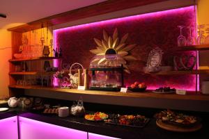 a bar with pink lighting and a fish tank on a counter at Pension zum Fässchen in Consrade