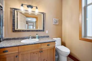 a bathroom with a sink and a toilet and a mirror at Blackrock 6 in Big White +45 photos