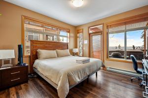 a bedroom with a bed and a desk and windows at Blackrock 6 in Big White