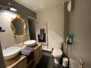 ein Badezimmer mit zwei Waschbecken, einer Toilette und einem Spiegel in der Unterkunft L'Ardoise in Bertrix