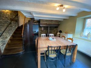 ein Esszimmer mit Tisch und Stühlen und eine Treppe in der Unterkunft L'Ardoise in Bertrix