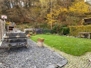 ein Hinterhof mit einem Tisch und einem Rasen in der Unterkunft L'Ardoise in Bertrix