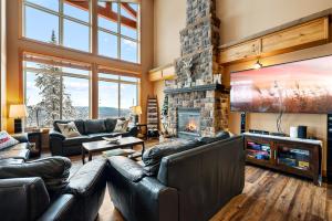 a living room with leather furniture and a stone fireplace at Blackrock 6 in Big White