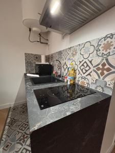 a kitchen with a black counter top and a sink at Le Cocon Dijonnais - Cours Cambronne in Dijon