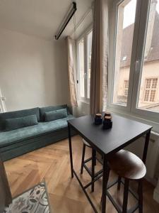 a living room with a couch and a table at Le Cocon Dijonnais - Cours Cambronne in Dijon