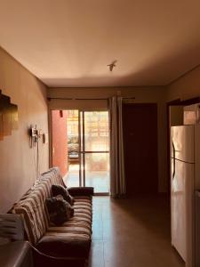 a living room with a couch and a refrigerator at Aconchego Atalaia in Luis Correia