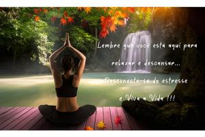 a woman sitting in a yoga pose in front of a waterfall at Villa Di Mare 2 - Pool, fire pit, and barbecue grill in São Francisco do Sul