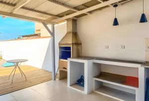 a kitchen with a stove and a table on a deck at Villa Di Mare 2 - Pool, fire pit, and barbecue grill in São Francisco do Sul
