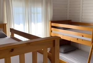 a bedroom with two bunk beds and a window at Villa Di Mare 2 - Pool, fire pit, and barbecue grill in São Francisco do Sul +49 photos