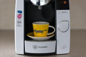 a coffee machine with a yellow coffee cup in it at Cambridge Orchard Apartments - 2 double bedrooms in Cambridge