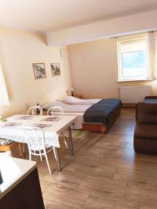 a room with a bed and a table and chairs at KAJA Zawoja in Zawoja