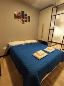 a bedroom with a blue bed with two towels on it at Departamento - Salta Capital ae - Edificio Usina in Salta