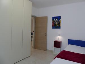 a bedroom with a bed and a door to a room at Andrea Appartamenti in Savona