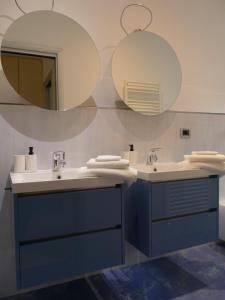 a bathroom with two sinks and two mirrors at Andrea Appartamenti in Savona +15 photos
