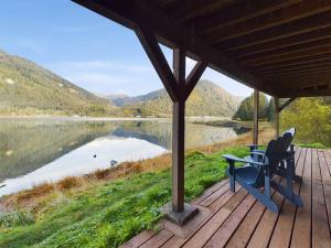a porch with two chairs and a table and a lake at Oceanfront Apartment with Sauna and Covered Deck in Juneau