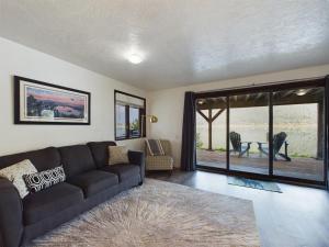 a living room with a couch and a large window at Oceanfront Apartment with Sauna and Covered Deck in Juneau