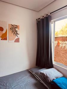 a bedroom with a window with a bed and a curtain at Aconchego Atalaia in Luis Correia +36 photos