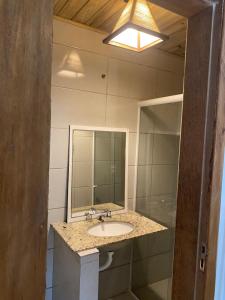 a bathroom with a sink and a mirror at InnFloripa - Pousada no Campeche 7 min do Aeroporto in Florianópolis +54 photos