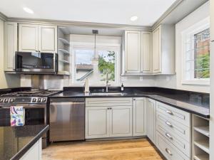 a kitchen with white cabinets and a sink at Oceanfront w Incredible Views in Juneau +23 photos