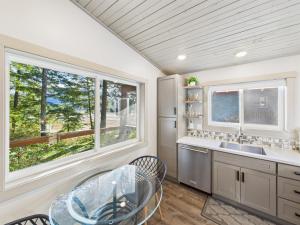 a kitchen with a glass table and a window at Sunny Point 2BR with Deck & Mountain Views in Juneau