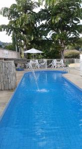 una fuente de agua en una piscina azul en Pousada Canto do Sabiá - Pirenópolis en Pirenópolis