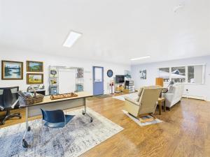 a living room with a desk and chairs at Large Juneau Loft w Full Kitchen, WD & Workspace in Juneau