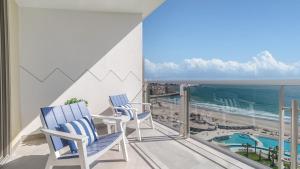 two chairs on a balcony with a view of the ocean at Luxury Oceanfront Condo with Stunning Views in Puerto Peñasco