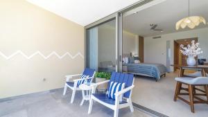 a living room with blue chairs and a bedroom at Luxury Oceanfront Condo with Stunning Views in Puerto Peñasco +18 photos