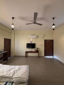 a living room with a ceiling fan and a tv at Platform 9 3by4 in Ujjain