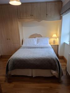 a bedroom with a bed with a wooden floor at Teach Kitty Con in Dungloe