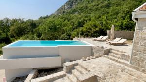 a villa with a swimming pool on a hill at Luxury stone house with infinity pool in Herceg-Novi