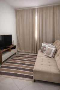 a living room with a couch and a flat screen tv at Lar Urbano in Manhuaçu