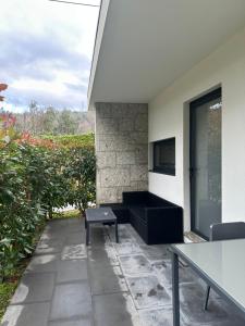 a patio with a table and a bench and a building at Ri&Vale Alojamentos in Vieira do Minho