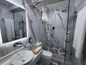 a bathroom with a sink and a toilet and a shower at Atlantis Hotel Lagos in Lagos +43 photos
