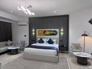 a bedroom with a king sized bed and a couch at Atlantis Hotel Lagos in Lagos