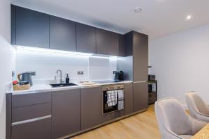 a kitchen with gray cabinets and a sink at Leeds Lux Apartment - 2 Bed & Pool Table, Secure Parking in Leeds