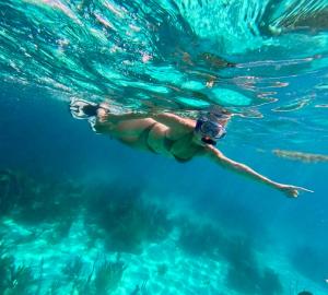 a woman is swimming in the water at Witzob Glamping Adventures in Santa Elena
