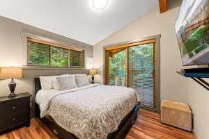a bedroom with a bed and a large window at JDF Waystation Cabin - Garden View - Pet Friendly in Port Renfrew