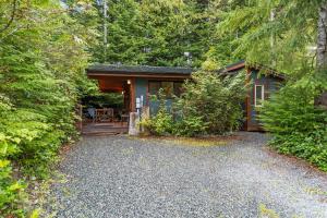 a small house in the middle of a forest at JDF Waystation Cabin - Garden View - Pet Friendly in Port Renfrew