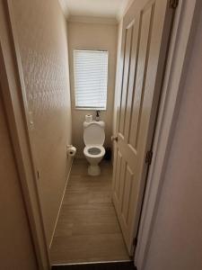 a small bathroom with a toilet and a window at Sunsets over Unsworth in Auckland +6 photos