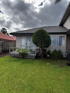 a house with a tree in the yard at Sunsets over Unsworth in Auckland