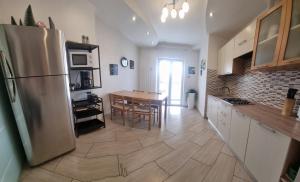 a kitchen with a stainless steel refrigerator and a table at Appartamento Valentinis 74 in Monfalcone