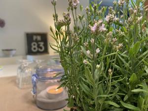 a candle and a vase with flowers on a table at Ferienwohnungen Bosbuell Huus in Bosbüll +39 photos