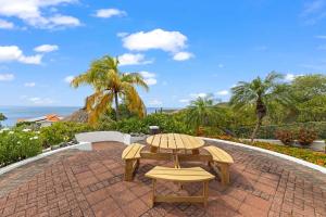 a table and chairs on a brick patio with the ocean at Villa Strelitzia in Dorp Soto