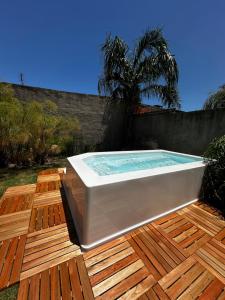 a hot tub sitting on a deck next to a fence at El descanso in Ramallo