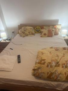 a bed with a remote control on top of it at Kay Borsa in Alba Iulia