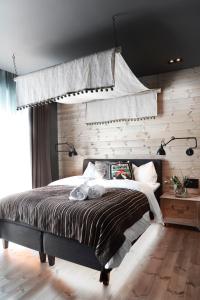 a bedroom with a bed with a wooden wall at Solsiden Brygge Rorbuer in Ballstad +190 photos