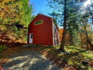 a red barn in the middle of a forest at Fiddlehead Greens in Warren