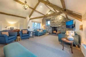 a living room with blue furniture and a stone fireplace at Melin-Bennar in Dyffryn