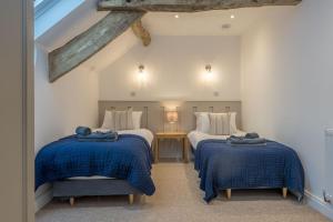 a bedroom with two beds with blue blankets at Melin-Bennar in Dyffryn